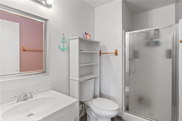 bathroom with a shower with door, vanity, and toilet