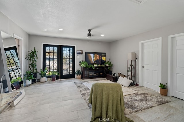 interior space with ceiling fan, a textured ceiling, and french doors