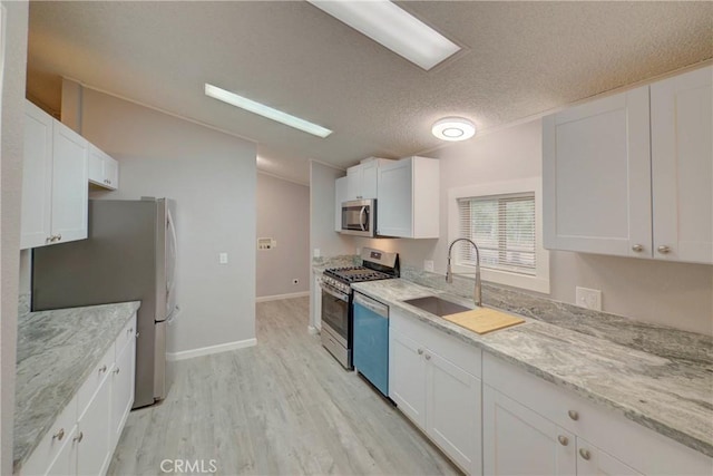 kitchen featuring white cabinets, light hardwood / wood-style floors, and stainless steel appliances