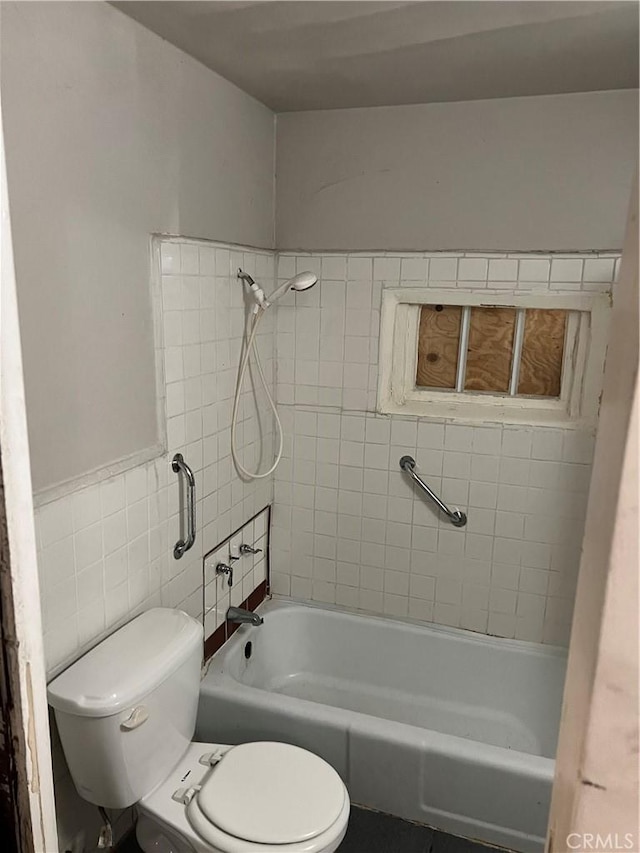 bathroom featuring tile walls, toilet, and shower / tub combination