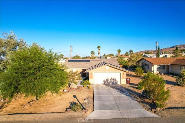 ranch-style home featuring solar panels and a garage