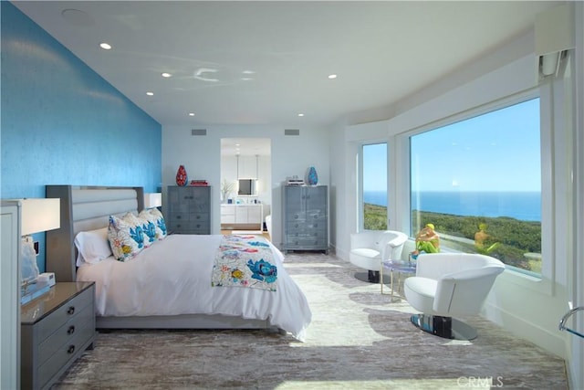 bedroom with a water view and multiple windows