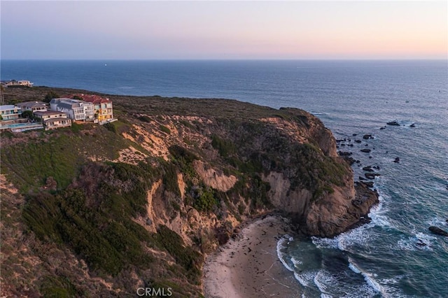 aerial view at dusk featuring a water view