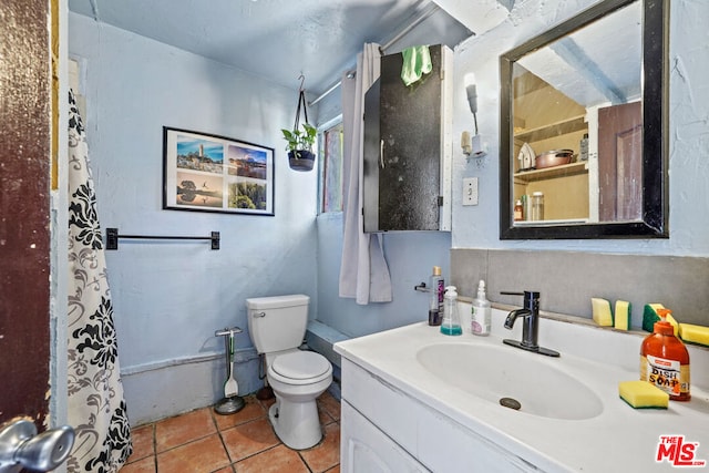 bathroom with toilet, tile floors, and large vanity