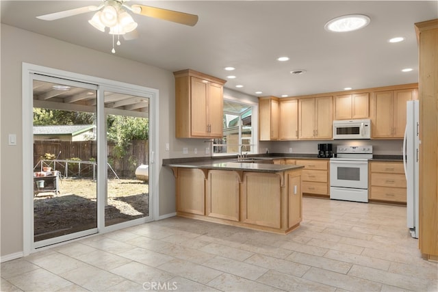 kitchen with light brown cabinetry, ceiling fan, white appliances, sink, and kitchen peninsula