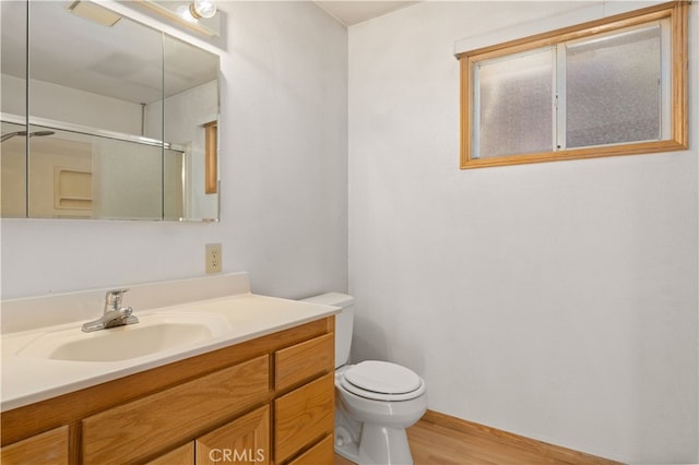 bathroom with toilet, vanity, and hardwood / wood-style floors