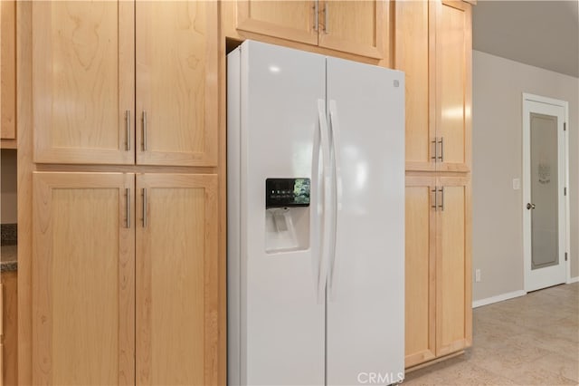 kitchen with light tile flooring, light brown cabinets, and white fridge with ice dispenser