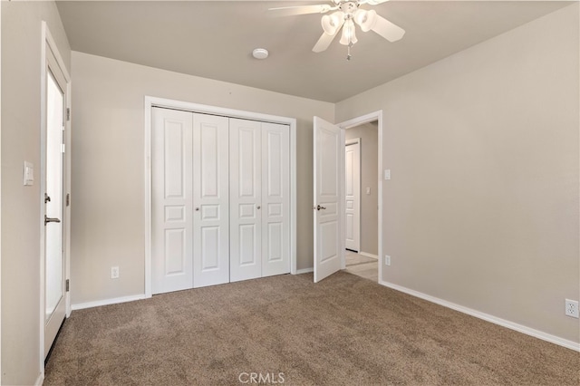 unfurnished bedroom with ceiling fan, a closet, and dark colored carpet