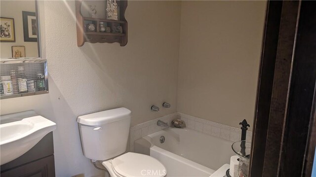 bathroom featuring a bath, vanity, and toilet