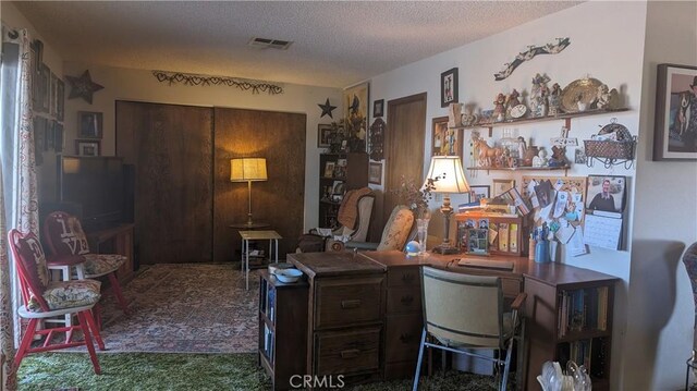 carpeted home office with a textured ceiling