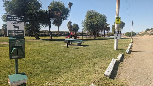 view of home's community with a playground and a lawn