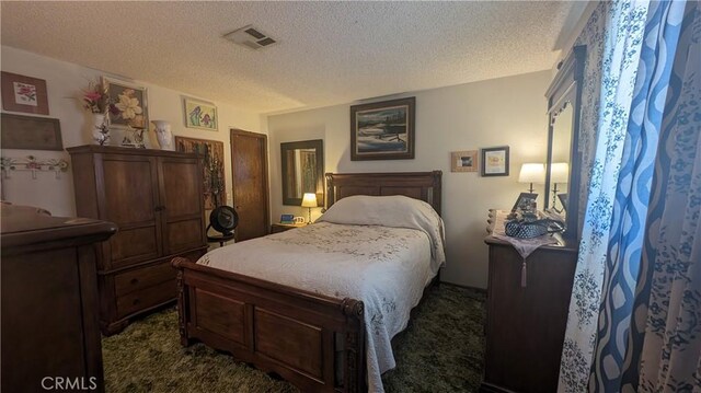 bedroom featuring a textured ceiling and dark carpet