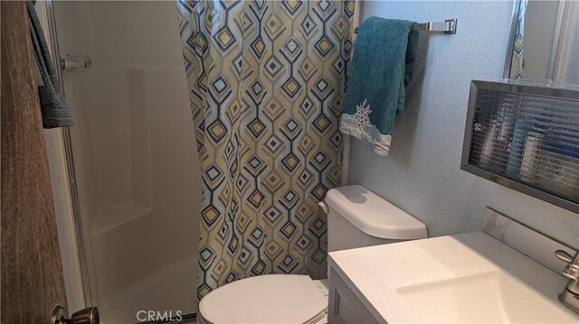 bathroom with a shower with curtain, toilet, and vanity