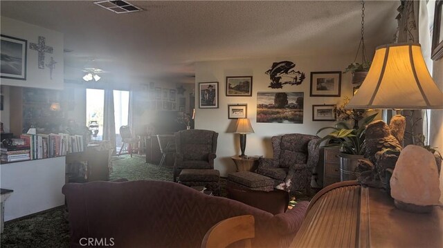 living room featuring carpet, a textured ceiling, and ceiling fan