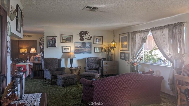 carpeted living room featuring a textured ceiling