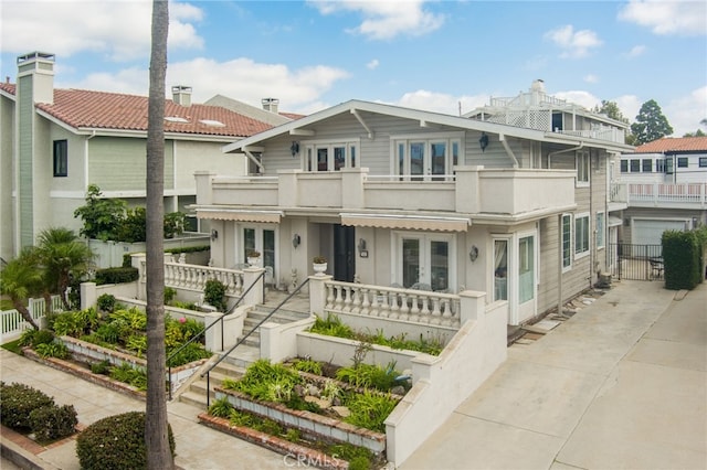 view of front of property with a balcony and french doors