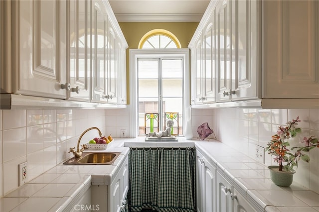 kitchen with backsplash, sink, and white cabinetry