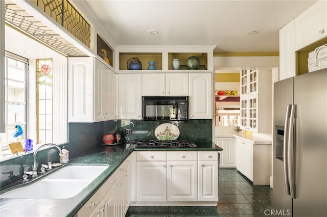 kitchen featuring decorative backsplash, sink, white cabinets, and black appliances