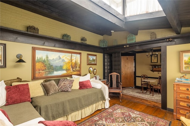 bedroom with wood-type flooring and beam ceiling