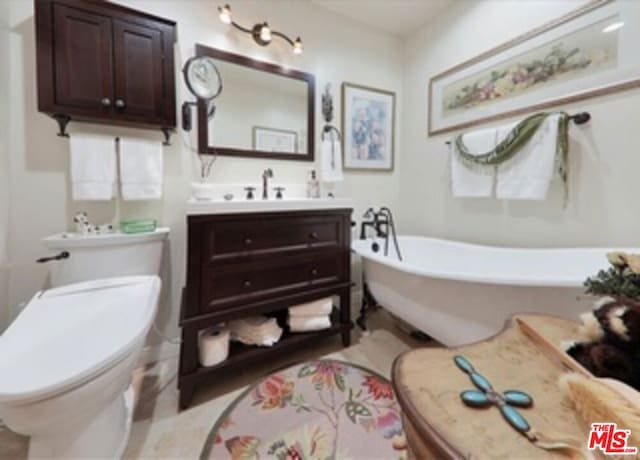 bathroom with a tub to relax in, vanity, and toilet