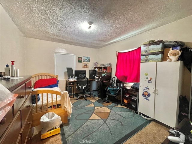 carpeted home office featuring a textured ceiling