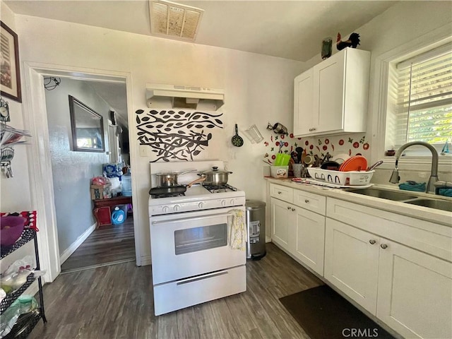 kitchen featuring dark wood-type flooring, sink, white cabinetry, and white gas range oven