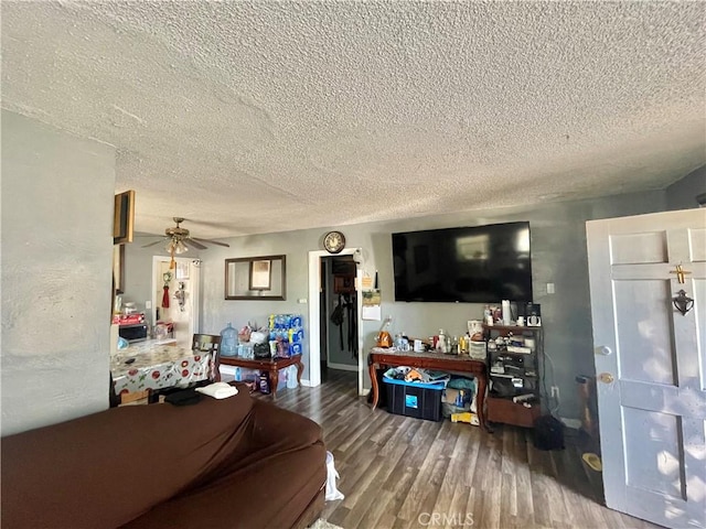 living room with ceiling fan, wood-type flooring, and a textured ceiling