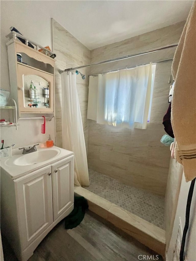 bathroom with curtained shower, wood-type flooring, and vanity