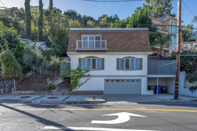 view of front of home featuring a balcony and a garage