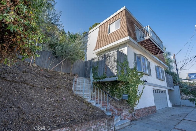 view of property exterior with a balcony and a garage