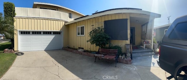 2922 Radnor Ave, Long Beach, CA 90815 - view of front of house with a garage, board and batten siding, and concrete driveway