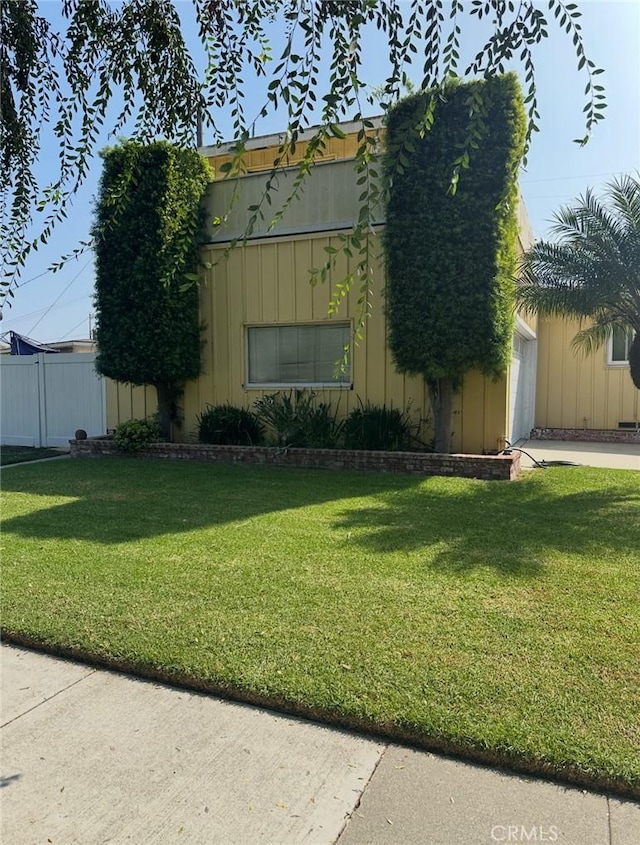 2922 Radnor Ave, Long Beach, CA 90815 - view of front of property with a garage, fence, board and batten siding, and a front lawn