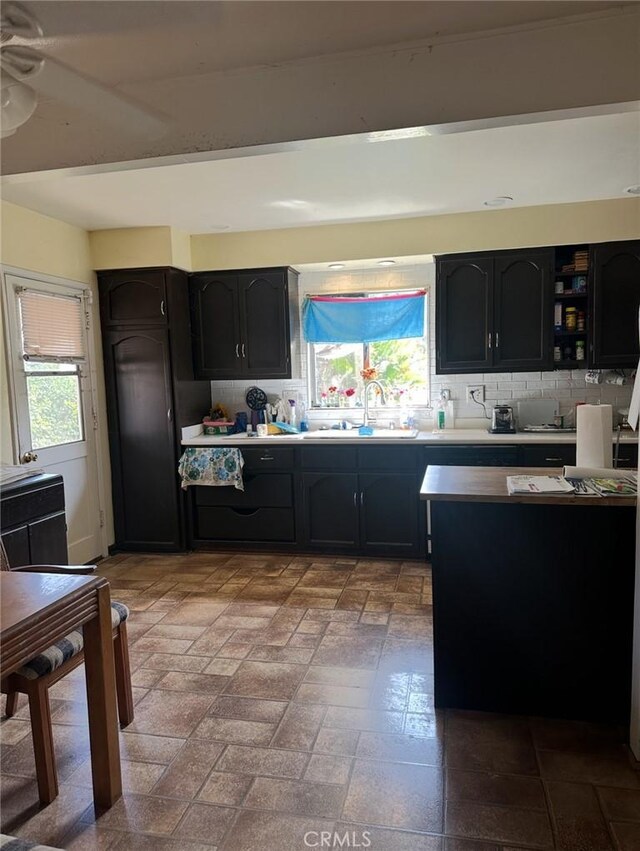 2922 Radnor Ave, Long Beach, CA 90815 - kitchen featuring decorative backsplash, dark cabinets, a wealth of natural light, and a sink