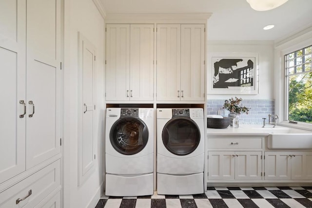 laundry area featuring cabinets, sink, ornamental molding, and washing machine and dryer