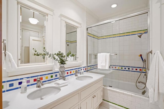 bathroom with vanity, decorative backsplash, shower / bath combination with glass door, and ornamental molding