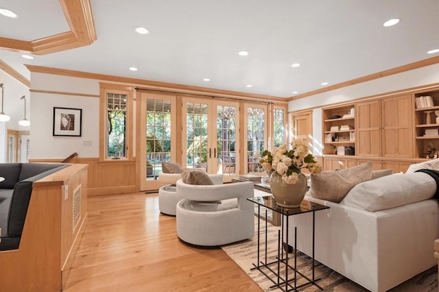 living room with light wood-type flooring, ornamental molding, and french doors