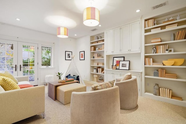 sitting room featuring light colored carpet, built in features, and french doors