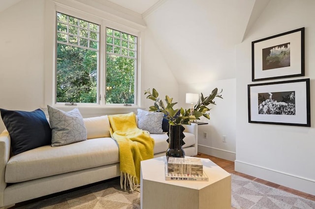 sitting room with crown molding, lofted ceiling, and light hardwood / wood-style floors