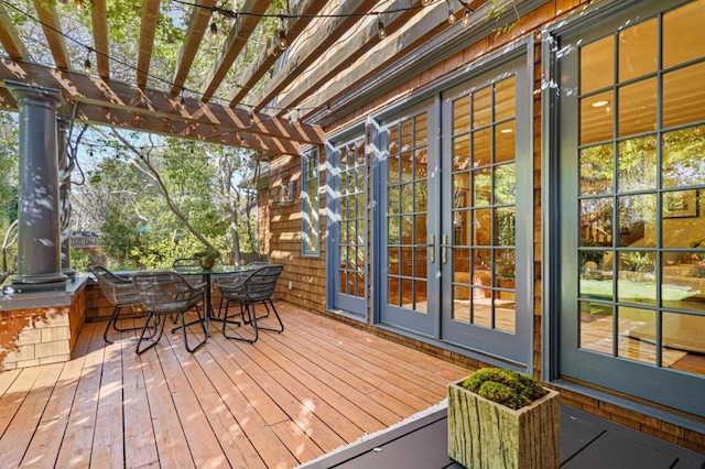 wooden terrace featuring french doors and a pergola