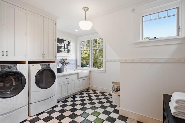 laundry area with washing machine and dryer, cabinets, crown molding, and sink