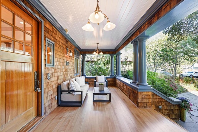 sunroom with a notable chandelier and decorative columns