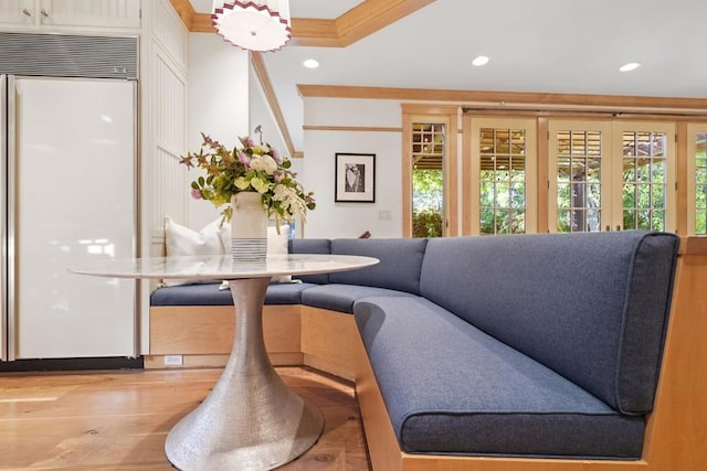 living room with light wood-type flooring and ornamental molding