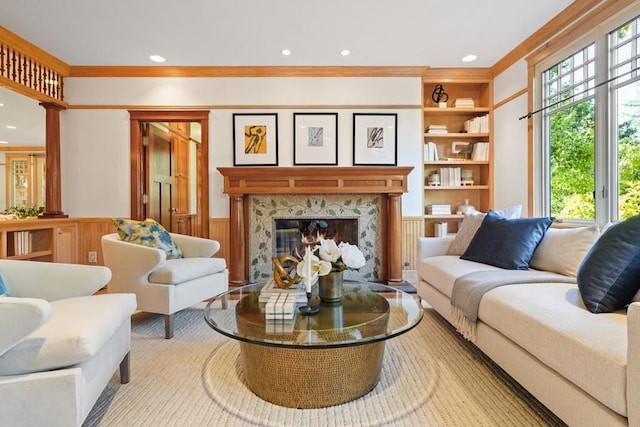 living room with wood walls, a high end fireplace, built in features, and ornamental molding