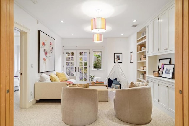 living area with light colored carpet, built in features, and french doors