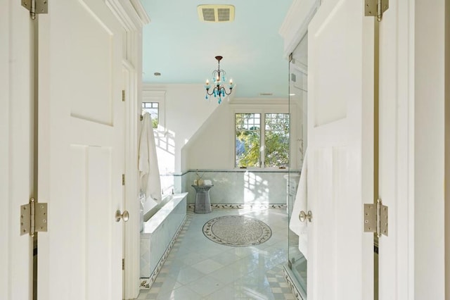 bathroom with an inviting chandelier and tile patterned floors