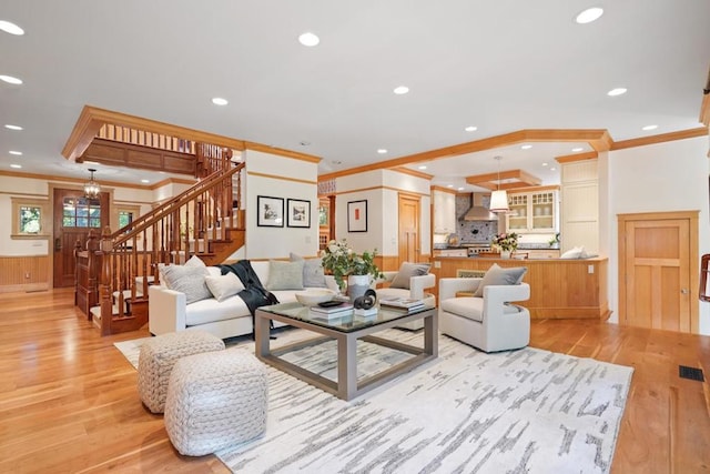 living room featuring crown molding and light hardwood / wood-style flooring