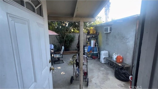 view of patio with fence and a wall mounted AC