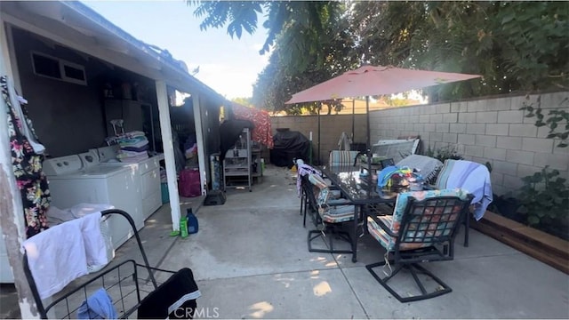 view of patio featuring a fenced backyard, a grill, outdoor dining area, and independent washer and dryer