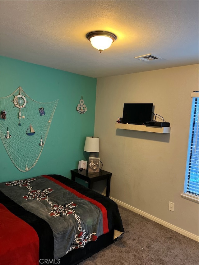 carpeted bedroom featuring a textured ceiling