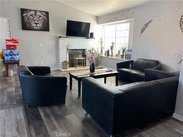 living room with hardwood / wood-style flooring, vaulted ceiling, and a fireplace